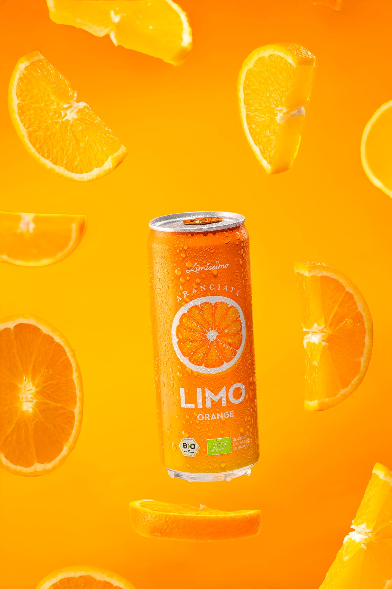 Limo-Dose Orange zwischen schwebenden Orangenscheiben vor orangem Hintergrund