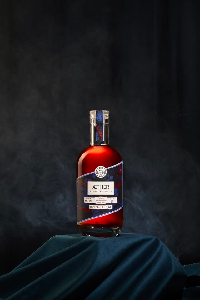 Flasche Äther Gin auf dunkelgrünem Samt vor dunklem Hintergrund