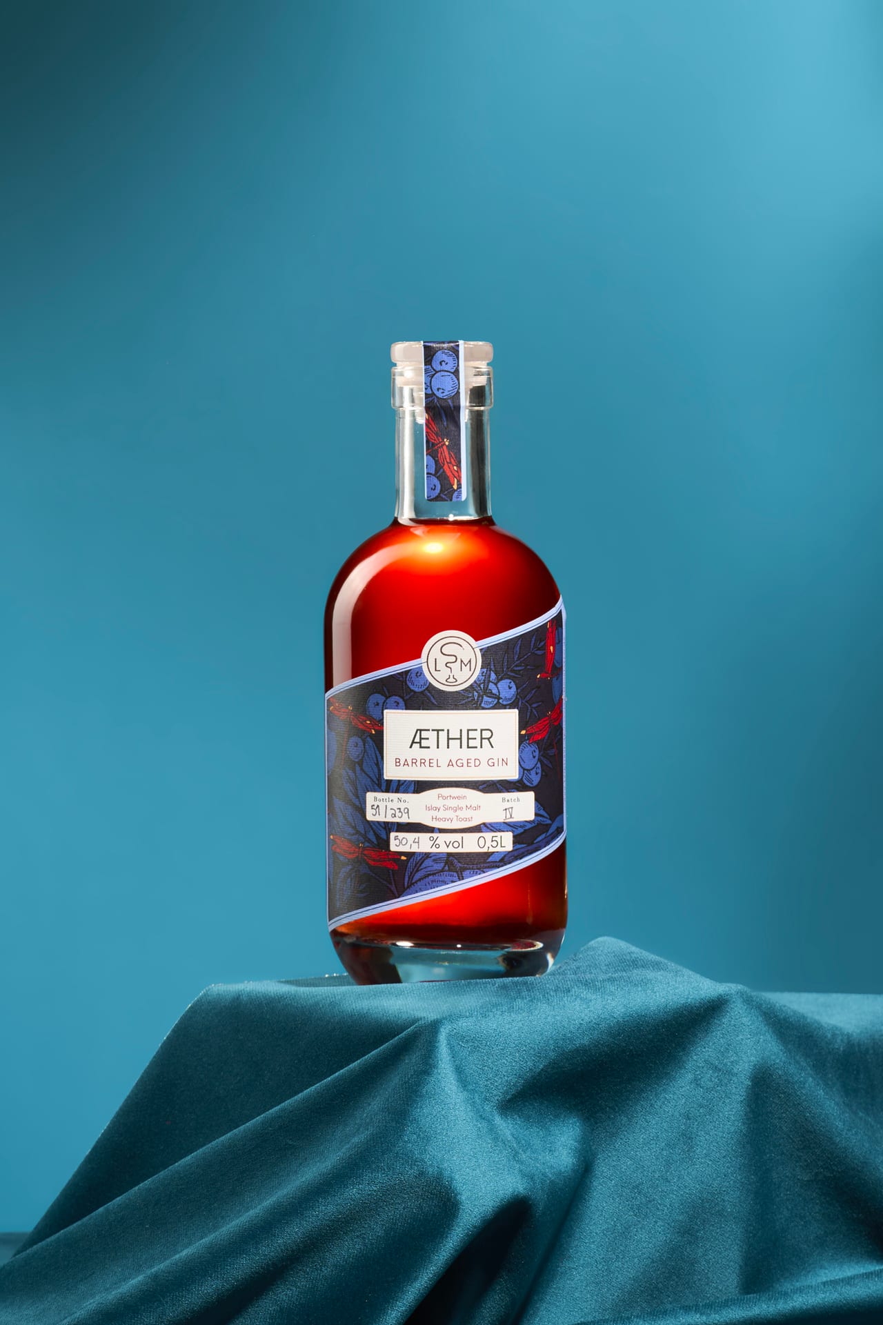 Gin im Glas mit Eiswürfel in warmem Gegenlicht
